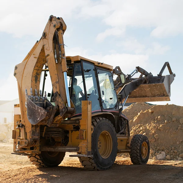 Véhicule de construction jaune et noir utilisé pour le nivellement de terrain.